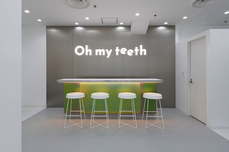 Oh my teeth池袋店のウェイティングエリア:「Oh my teeth」ネオンサインと白いスツール